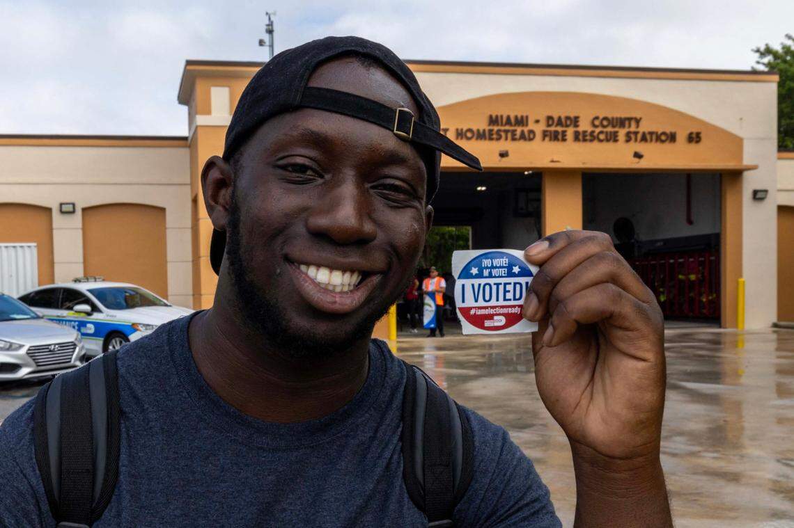 First generation American Ousmane Bangoura smiles as he holds up his ‘I VOTED’ sticker after casting his ballot during Election Day at Miami Dade County East Homestead Fire Station #65 on Tuesday, November 5, 2024, in Miami, Fla.