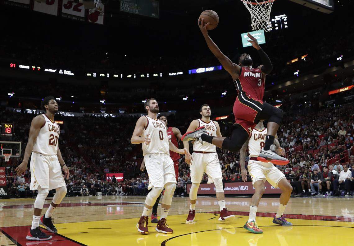 Miami Heat guard Dwyane Wade (3) drives to the basket past Cleveland Cavaliers guard Brandon Knight (20) and forward Kevin Love (0) during the second half of an NBA basketball game, Friday, March 8, 2019, in Miami.