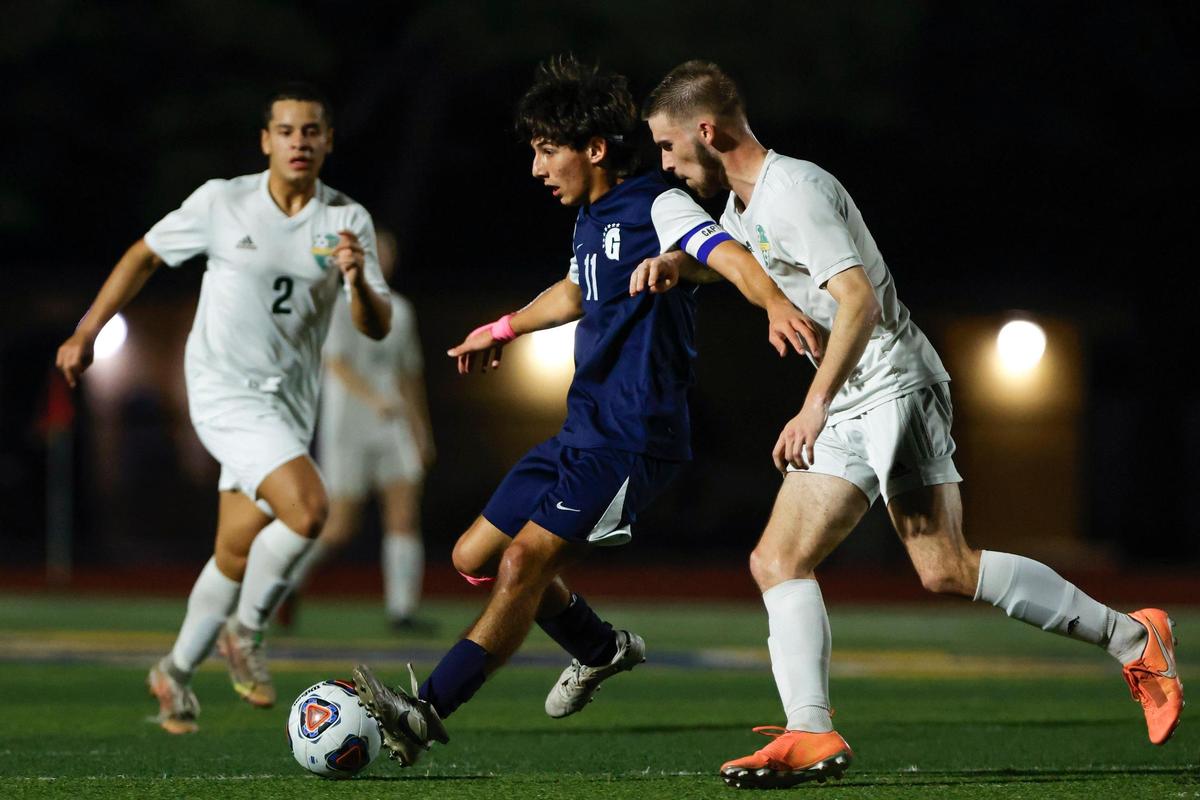 Gulliver Raiders Mateo Acosta-Rubio (11) protects the ball from a Yulee Hornets defender during the second half of the Region 4-4A semifinal game at Belen Jesuit Preparatory School in Tamiami, Florida on Saturday, February 18, 2023.