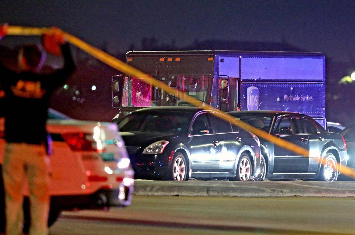 A police officer holds up crime tape at the scene of a shootout between robbers in a UPS delivery truck and police at Flamingo Road and Miramar Parkway in Miramar on Dec. 5, 2019. Four people were killed, including the robbers, a UPS driver who was taken hostage and a nearby motorist.