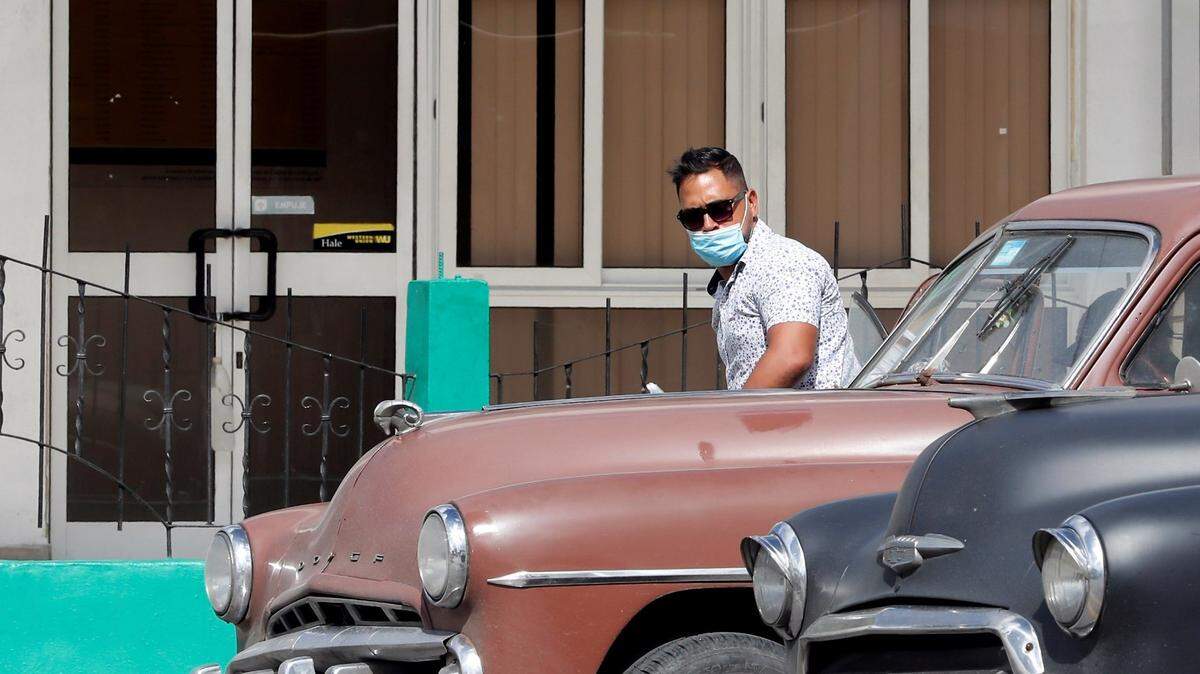 Two classic cars pass in front of a Western Union office in Havana, Cuba, 23 November 2020. EFE / Ernesto Mastrascusa/Sipa USA