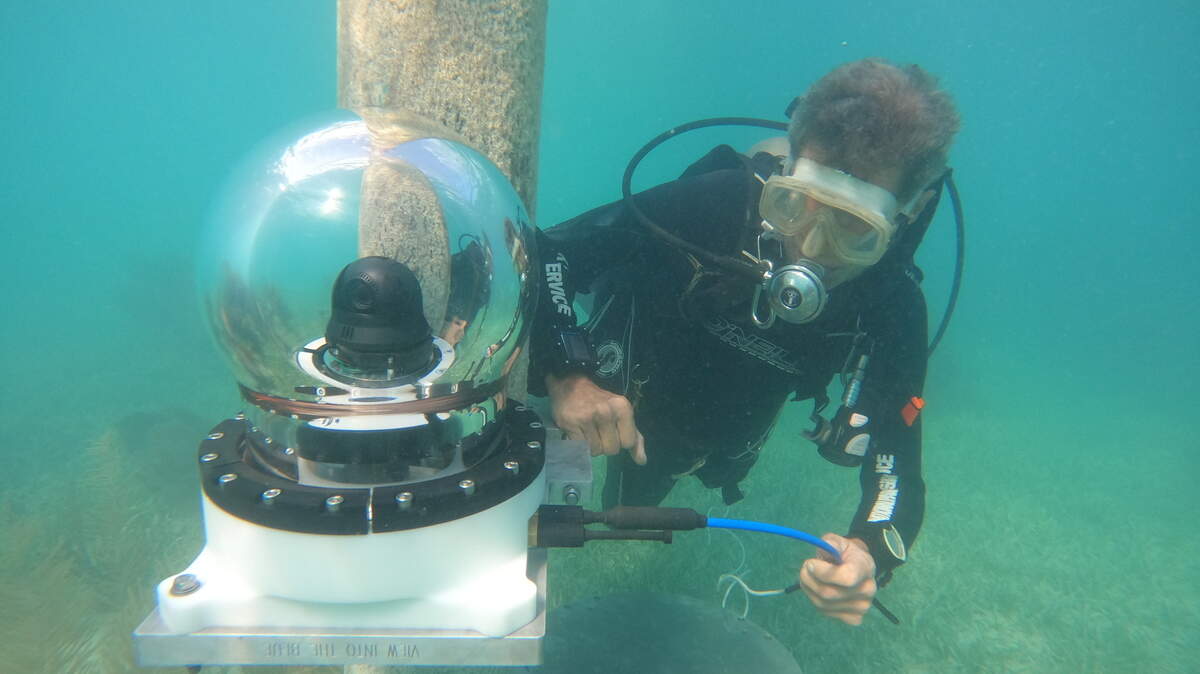 Troy Helmers, with the nonprofit Friends of John Pennekamp Coral Reef State Park, installs an underwater camera at Mosquito Banks within the state park.