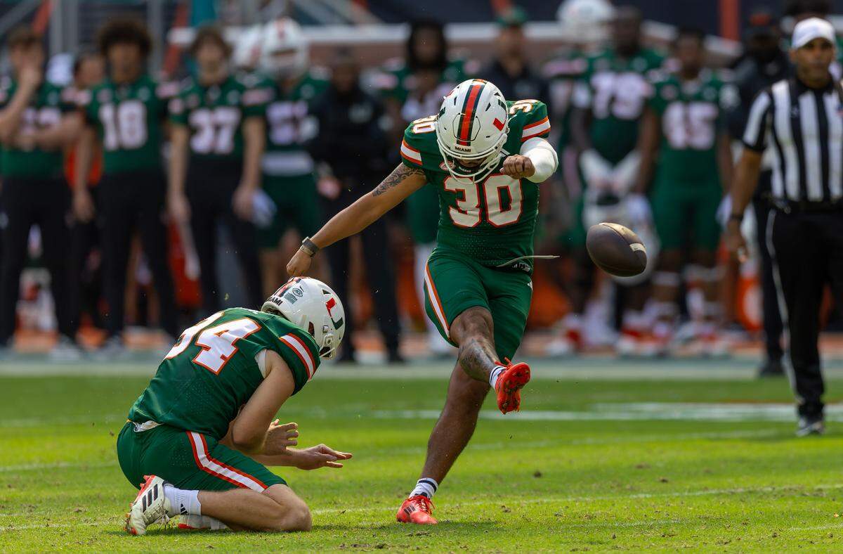 Miami Hurricanes place kicker Andres Borregales (30) kicks a field goal as punter Miami Hurricanes punter Dylan Joyce (94) left, holds the ball during the first half of an ACC football game against the Duke Blue Devils at Hard Rock Stadium on Saturday, Nov. 2, 2024, in Miami Gardens, Fla.