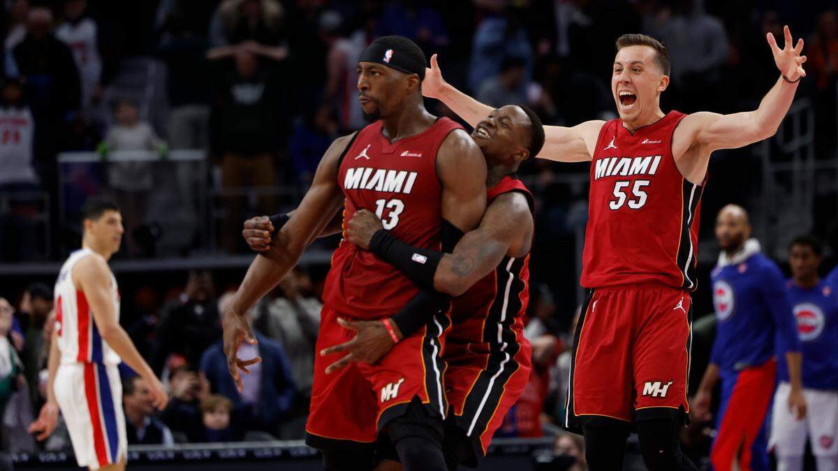 Miami Heat center Bam Adebayo (13) celebrates with guard Terry Rozier (2) and forward Duncan Robinson (55) after he hits a three point basket as time ran out to win the game against the Detroit Pistons at Little Caesars Arena.
