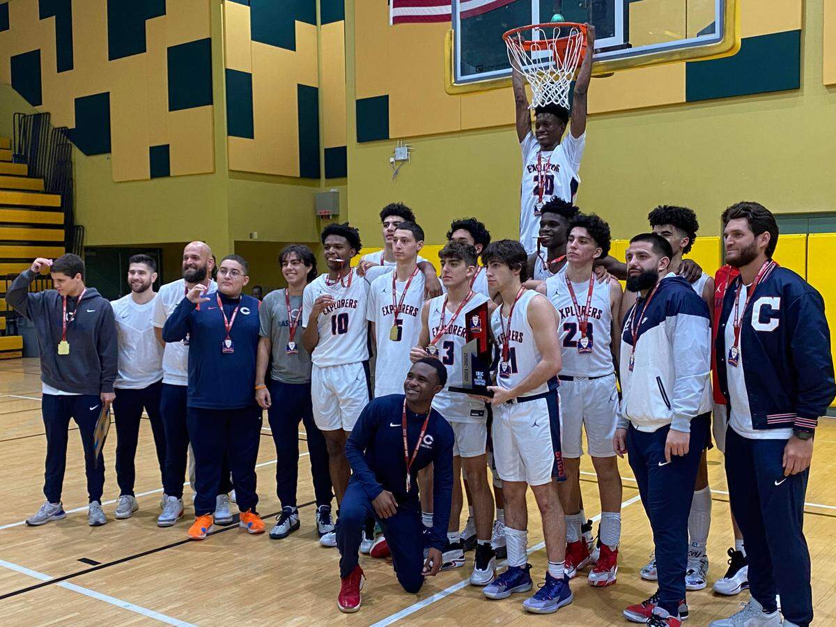Columbus’ basketball team celebrates - with guard Michael Feenane hanging from the rim - after its 61-53 victory over Norland on Thursday night in the GMAC boys’ basketball final at Miami Jackson.