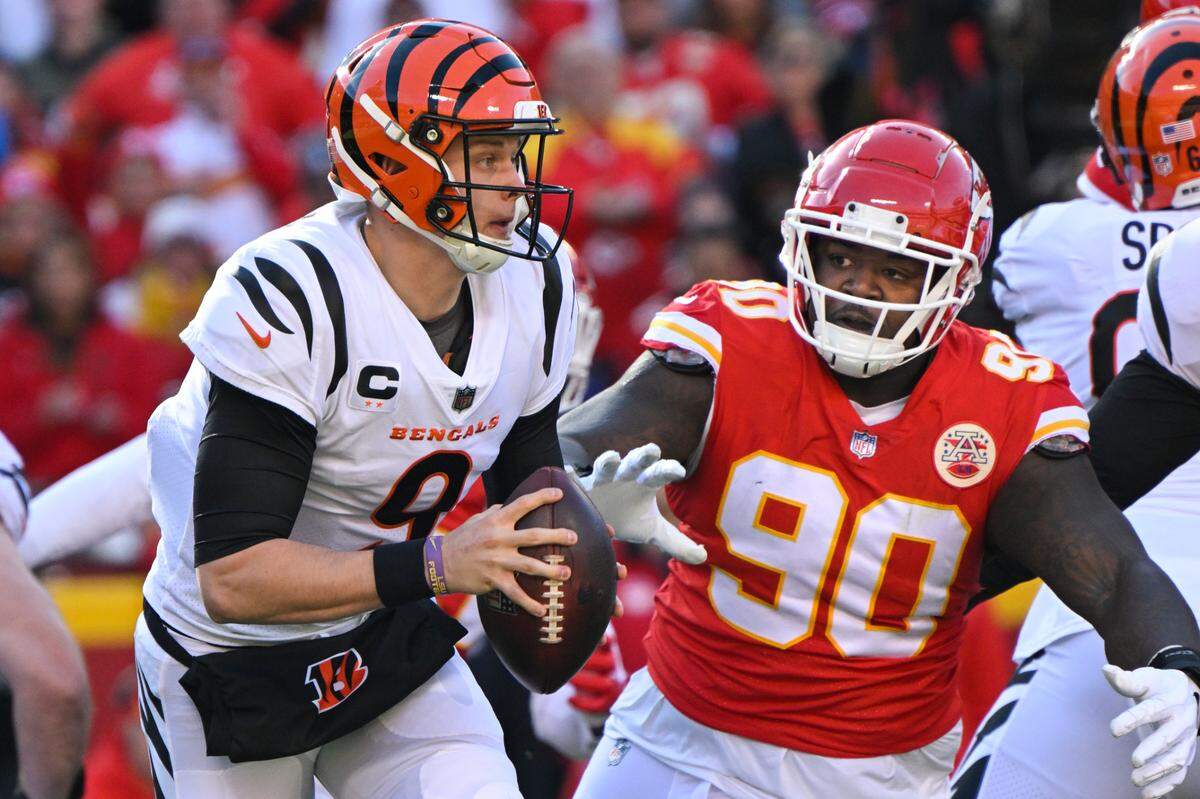Cincinnati Bengals quarterback Joe Burrow (9) is chased by Kansas City Chiefs defensive tackle Jarran Reed (90) during the first half of the NFL AFC Championship football game, Sunday, Jan. 30, 2022 in Kansas City, Mo.