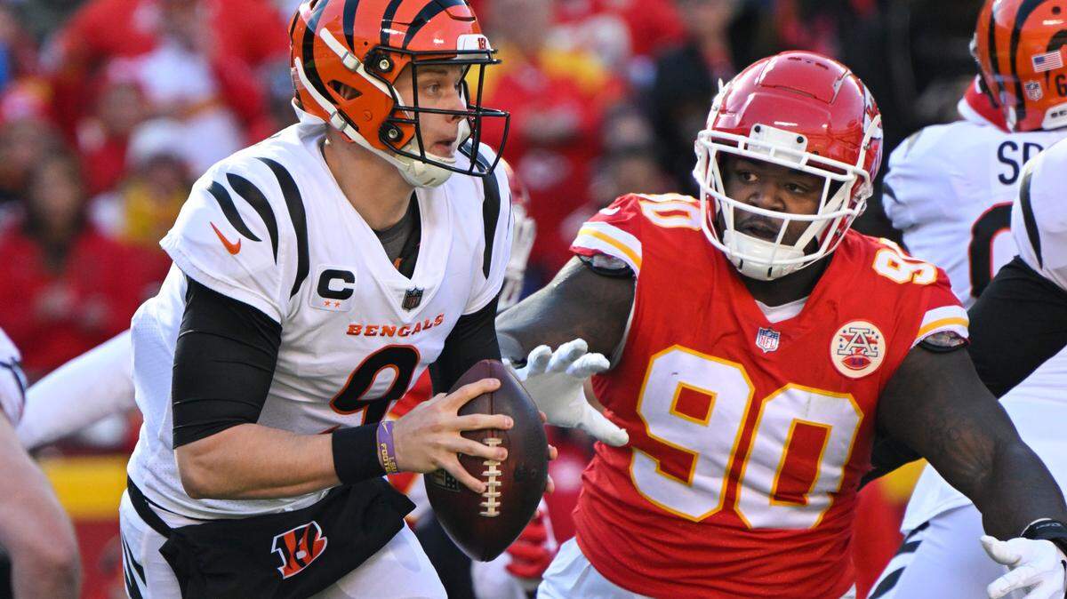 Cincinnati Bengals quarterback Joe Burrow (9) is chased by Kansas City Chiefs defensive tackle Jarran Reed (90) during the first half of the NFL AFC Championship football game, Sunday, Jan. 30, 2022 in Kansas City, Mo.