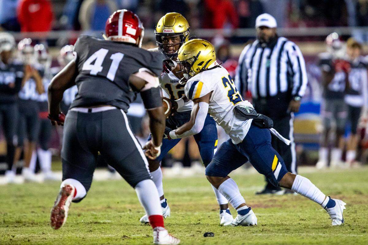 St. Thomas Aquinas High School quarterback Zion Turner (12) hands the ball off to running back Anthony Hankerson (22) during the second half of the Class 7A State Championship against Edgewater High School at Doak Campbell Stadium in Tallahassee, Florida, on Saturday, December 19, 2020.