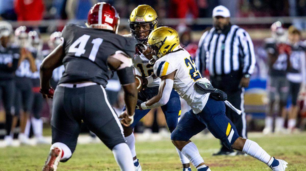 St. Thomas Aquinas High School quarterback Zion Turner (12) hands the ball off to running back Anthony Hankerson (22) during the second half of the Class 7A State Championship against Edgewater High School at Doak Campbell Stadium in Tallahassee, Florida, on Saturday, December 19, 2020.