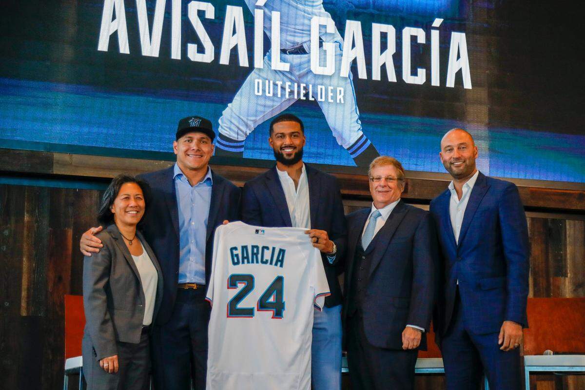 Newly signed Miami Marlins outfielder Avisaíl García, in cap, is introduced to the media joined by, from left, Miami Marlins General Manager Kim Ng, starting pitcher Sandy Alcántara, Marlins Chairman and principal owner Bruce Sherman, and Marlins CEO Derek Jeter during a presentation event at the Biscayne Bay Brew Hall of loanDepot park in Miami, Florida, Wednesday, Dec. 1, 2021.