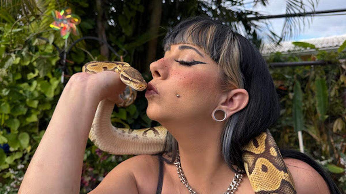 Crystal Ruth kisses Princess, a ball python.