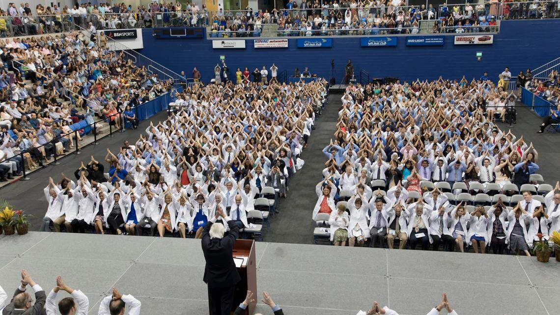Nova Southeastern University President Dr. George Hanbury gives a ‘Fins Up’ to the crowd of thousands at the joint White Coat Ceremony on Saturday.