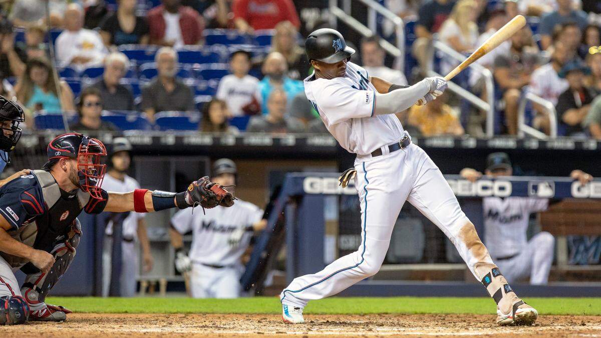 Miami Marlins center fielder Lewis Brinson (9) hits a single on a sharp ground ball to Braves right fielder Ronalds Acuña Jr. (13) during Sunday’s game.