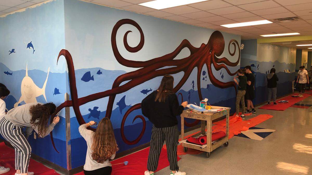 MAST students paint a marine-themed mural on their school’s walls. Eventually, with mentoring from visual artist and volunteer Jacqueline Roch and art specialist and MAST art teacher Eddy Lacayo, there will be murals like this on many other walls at the school.