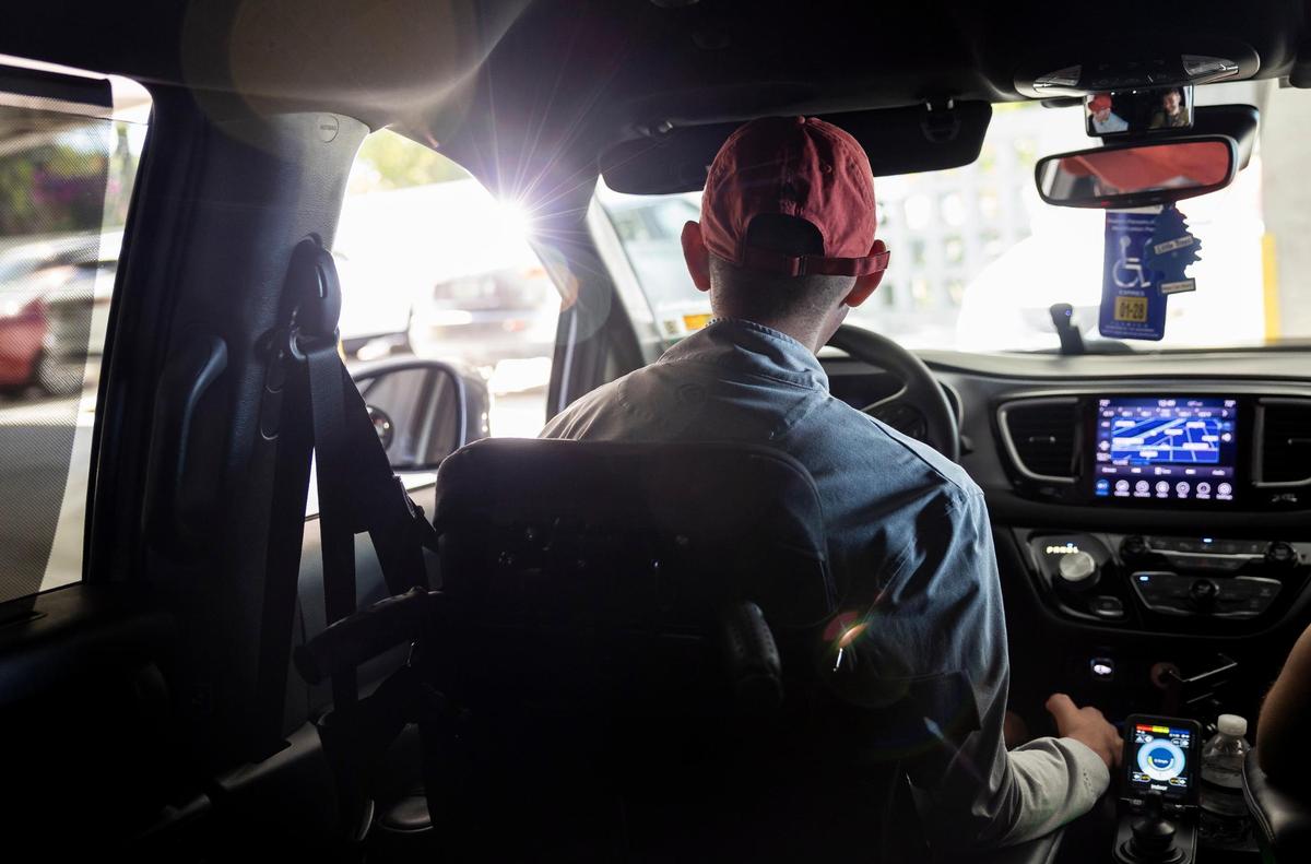 Gabriel Vergara, quien sufre de distrofia muscular, usa una herramienta especial para conducir su auto.