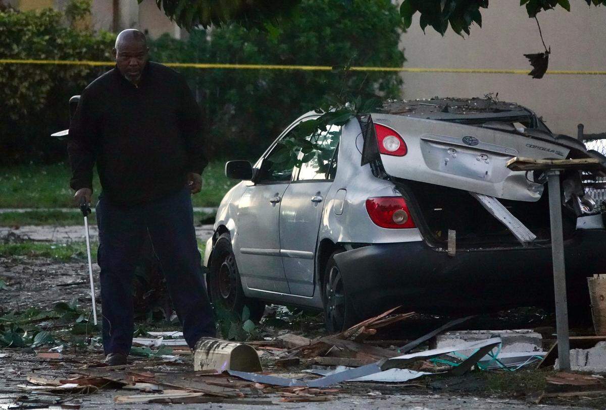 Firefighters investigate a house explosion in West Park, Florida, on Tuesday, Dec. 19, 2023.