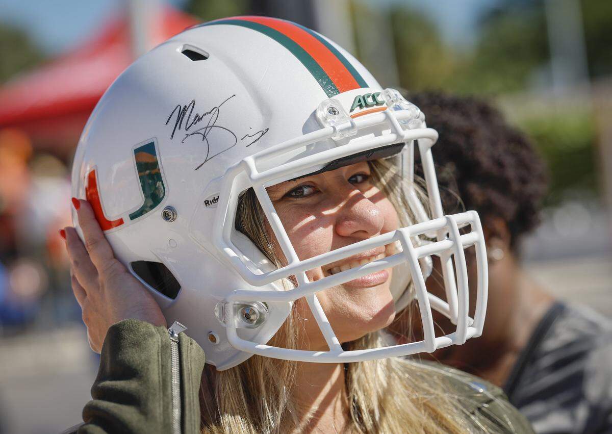 Canes fan Hulda Acevedo wears a UM football helmet during a Miami Hurricanes pep rally at the lakeside patio on the UM campus in Coral Gables, Florida, on Friday, Jan. 16, 2026.