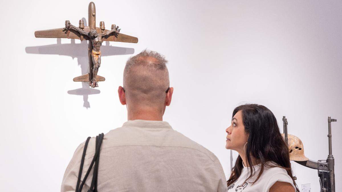 Dos personas miran una de las esculturas del artista Al Farrow.