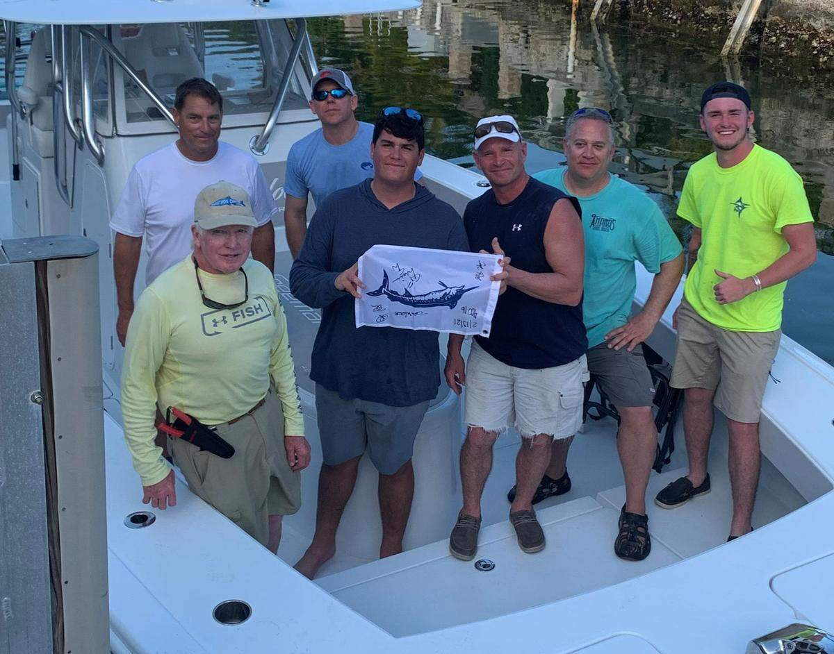 A group of anglers gather on a boat at a dock in Marathon in the Florida Keys after returning from a fishing trip where they caught a 450-pound blue marlin Saturday, Feb. 13, 2021. Pictured from the front row are Captain Rob Helzer, Fisher Dyle, Darin Westhoff, Russ Pilette, Davis Westhoff, Karl Dyle and Dennis Dixon.
