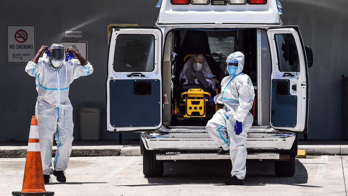 Medics prepare to transfer a patient on a stretcher from an ambulance to Coral Gables Hospital during the coronavirus pandemic.