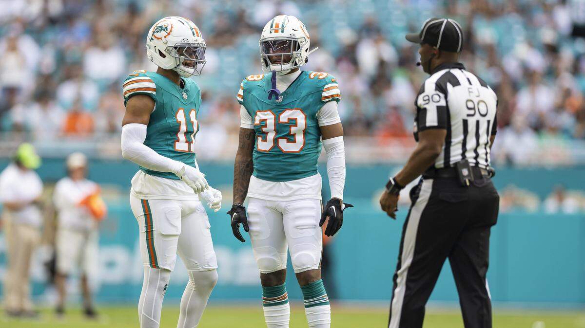 Miami Dolphins safety Dante Trader Jr. (11) and cornerback Jason Marshall Jr. (33) talk as they play against the Cincinnati Bengals in the first half of their NFL game at Hard Rock Stadium on Sunday, Dec. 21, 2025, in Miami Gardens, Fla.
