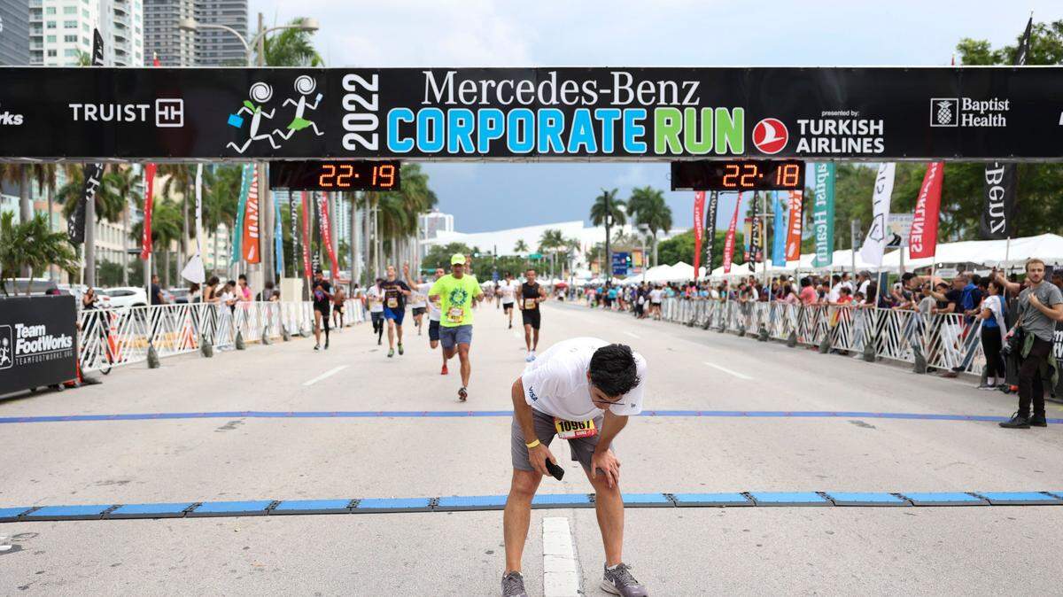 A man rests after crossing the finish line during the Miami Corporate Run starting at Bayfront Park in Miami on Thursday, April 28, 2022. Those dark clouds in the distance could return for this year’s run on April 27, 2023, but most activity will be further north, the weather service says.