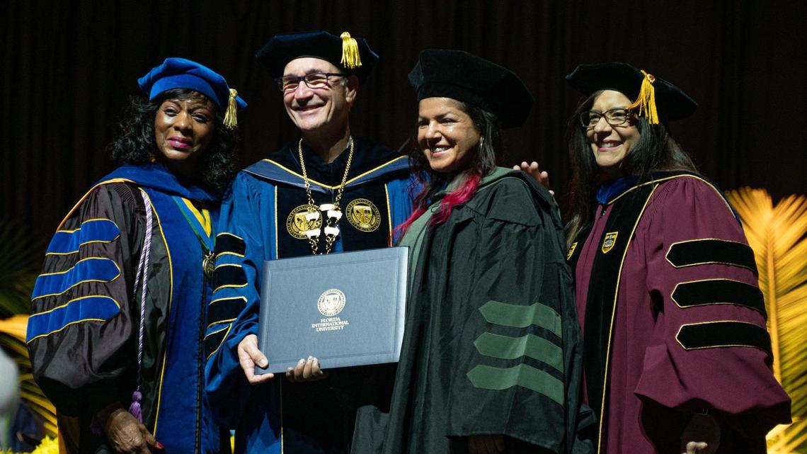 Aisha Visram, third from left, poses for a photo during commencement at the Ocean Bank Convocation Center at Florida International University’s Modesto A. Maidique campus in Miami on Tuesday, Dec. 13, 2022. She graduated with a doctorate in athletic training and was the first woman of color to work as an athletic trainer on a National Hockey League game day bench for the Los Angeles Kings.