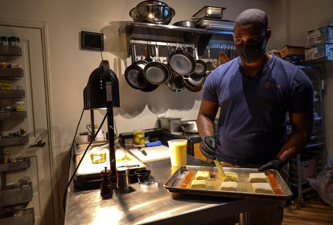 Akino West glazes biscuits he pairs with a signature fried chicken that he and his partner are selling out of their shuttered bed and breakfast, the Copper Door.
