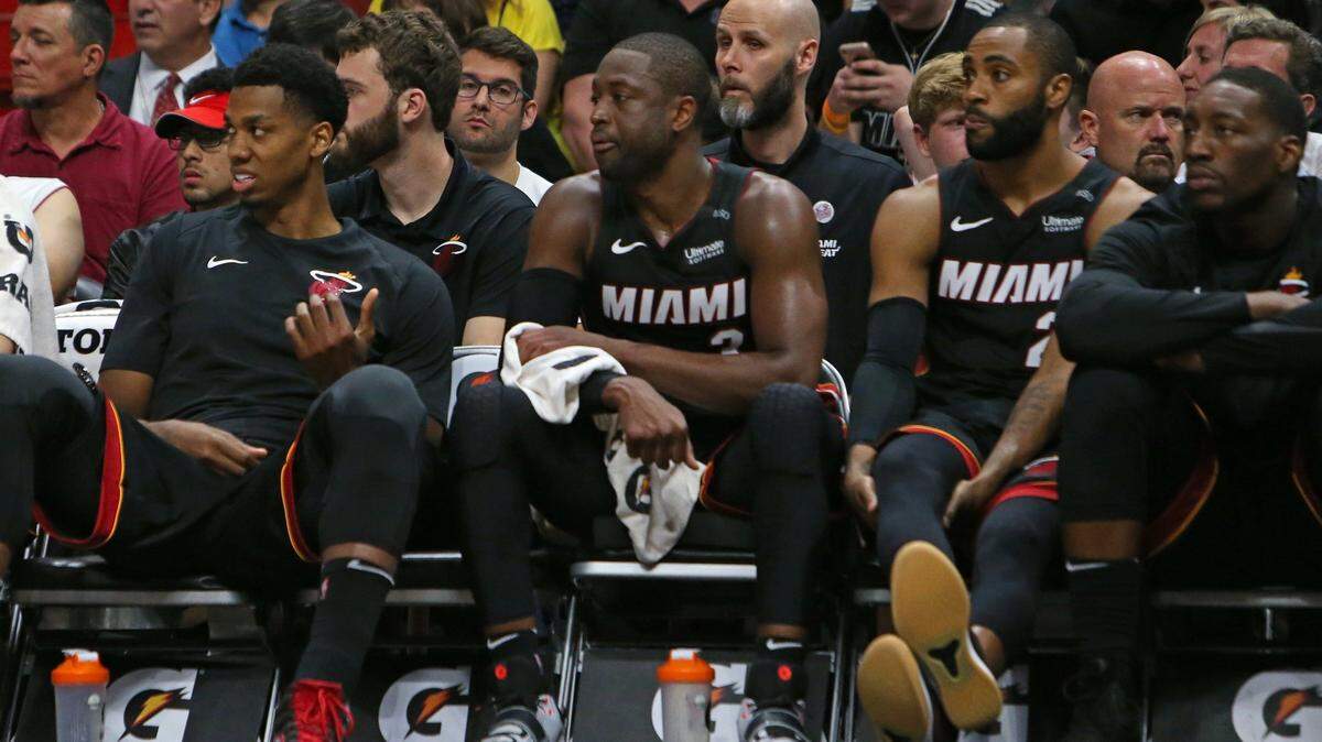 From left to right, Miami Heat players Hassan Whiteside, Dwyane Wade, Wayne Ellington and Bam Adebayo look from the bench during overtime of an NBA basketball game against the Brooklyn Nets at the AmericanAirlines Arena in Miami on Saturday, March 31, 2018.