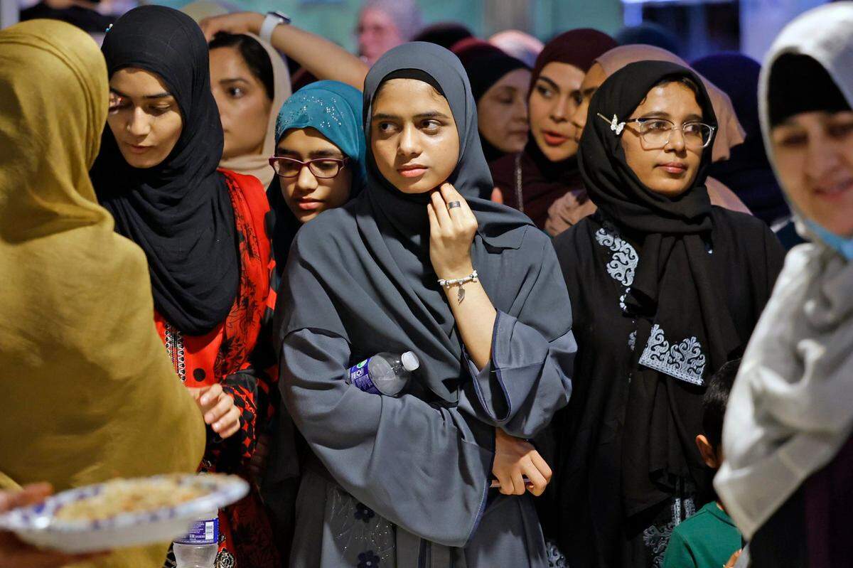 Aiman Siddiqui, center, waits with others as they prepare to end their fast and celebrate the Day of Arafah.