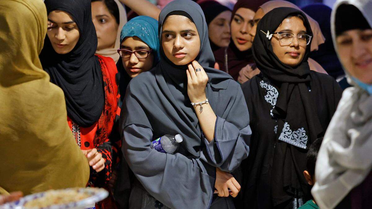 Aiman Siddiqui, at the center, joins others while waiting to end their fasting for the Day of Arafah at the Islamic Center of Greater Miami-Masjid in Miami Gardens, Tuesday, June 27, 2023.