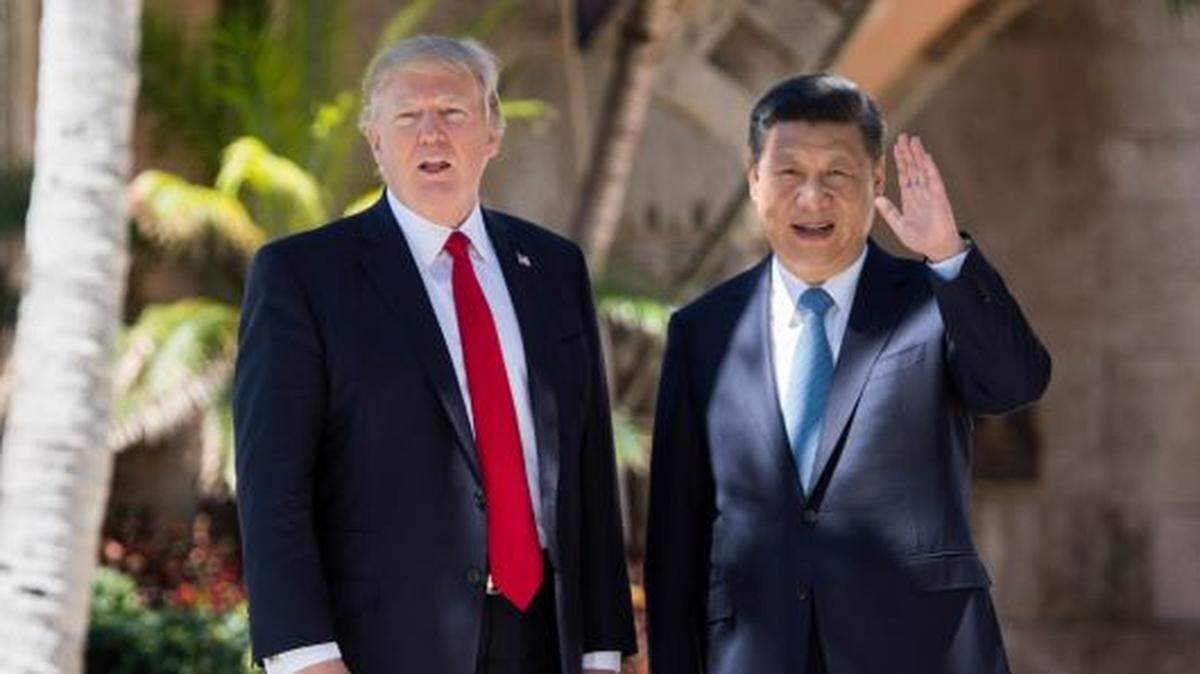 Chinese President Xi Jinping (R) waves to the press as he walks with U.S. President Donald Trump at the Mar-a-Lago estate in West Palm Beach, Florida, in 2017.