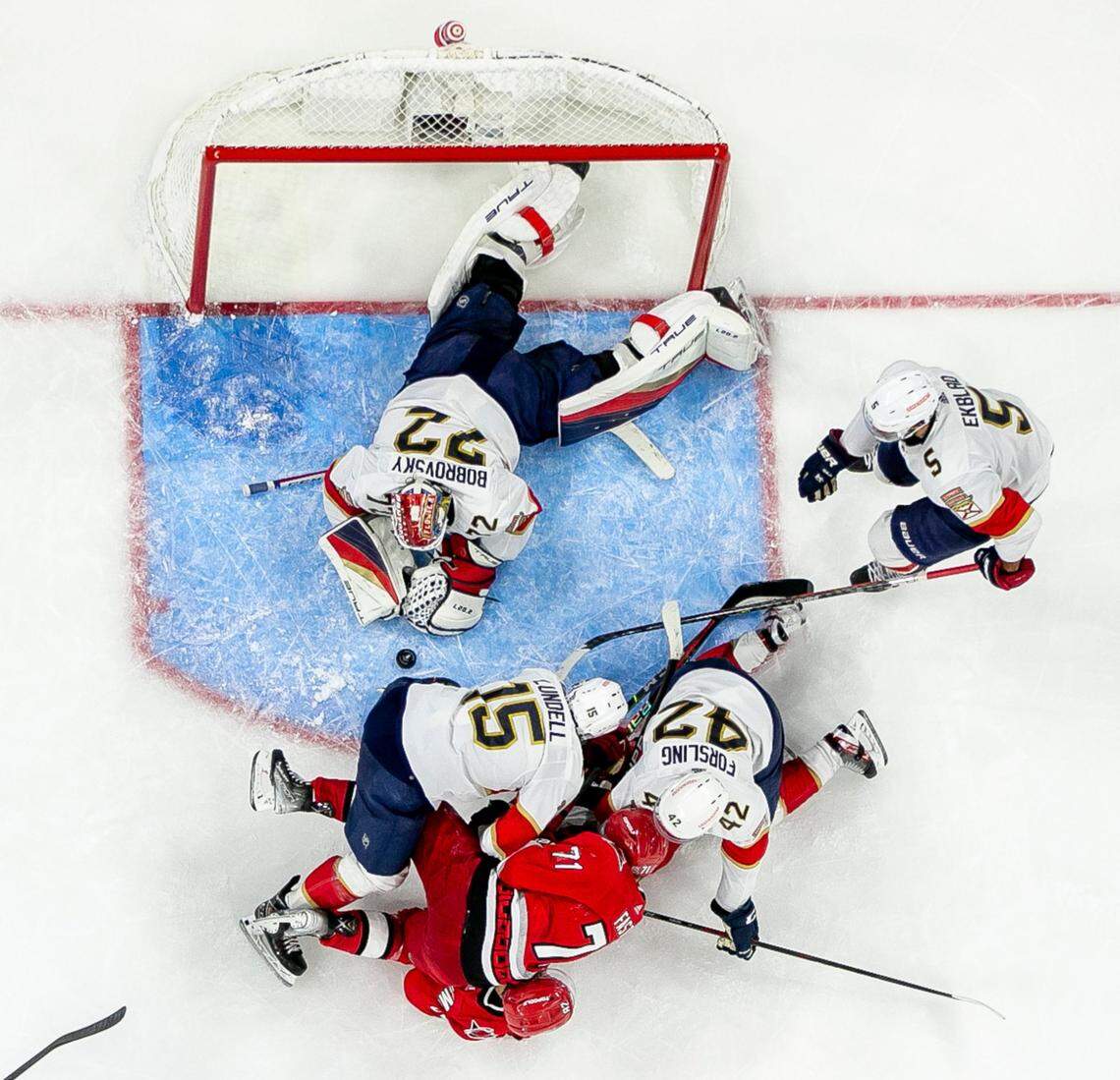 The Florida Panthers Anton Lundell (15) and Gustav Formling (42) smother the Carolina Hurricanes Jesper Fast (71) and Jesperi Kotkaniemi (82) with defense assisting goalie Sergei Bobrovsky (72) in the first overtime period during Game 1 of the Eastern Conference Finals on Friday, May 19, 2023 at PNC Arena in Raleigh, N.C.