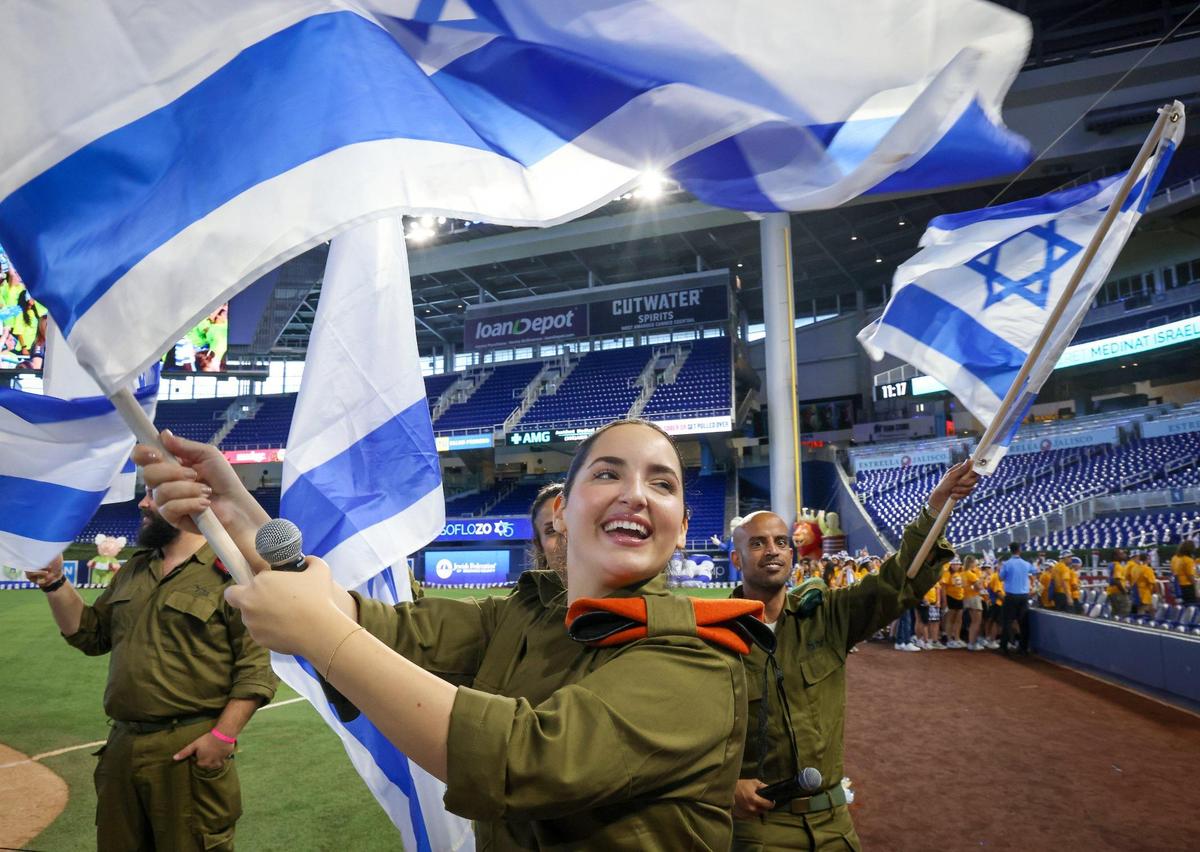 Israeli Defense Forces soldier Natalia Levi, center, joins in flying the Israeli flag with fellow military service personnel. On Wednesday, April 26, 2023, the South Florida community celebrated Israel’s 75th Independence Day.