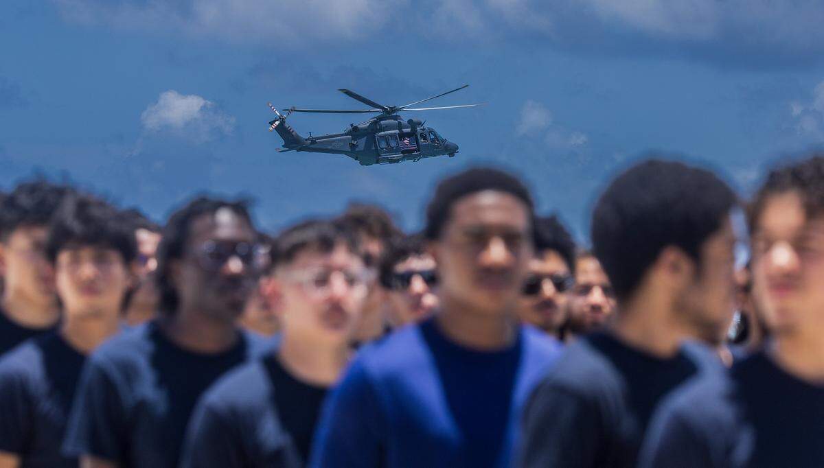 A helicopter flies over as group of future military members lined up at a special Enlistment Swearing-In Ceremony honoring the next generation of American service members in South Beach during the Hyundai Air & Sea Show annual National returns Salute to America's Heroes for Memorial Day Weekend celebration, in Miami Beach, on Saturday, May 23, 2026