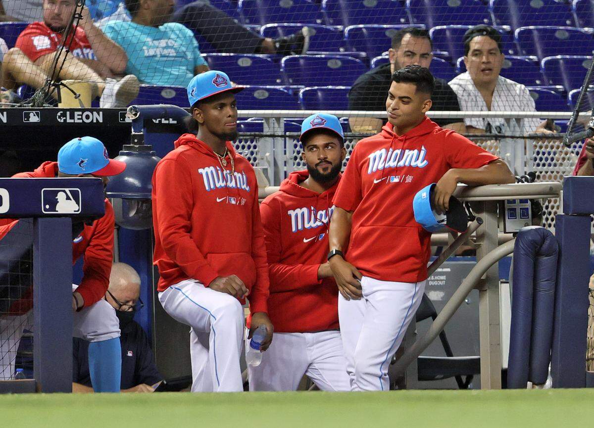 From left, Miami Marlins Edward Cabrera, Sandy Alcantara and Jesus Luzardo look from the dugout during the eighth inning of their game against the Philadelphia Phillies at loanDepot park on Sunday, Sept. 5, 2021, in Miami, Florida.