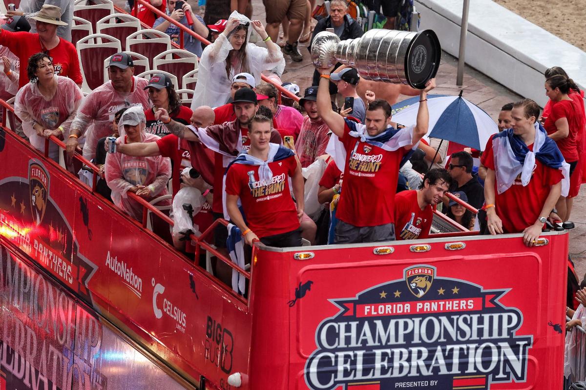 Florida Panthers center Aleksander Barkov lifts the Stanley Cup alongside teammates as fans cheers during the Florida Panthers victory parade before the Stanley Cup victory parade at Fort Lauderdale Beach on Tuesday, June 30, 2024 in Fort Lauderdale.&nbsp;