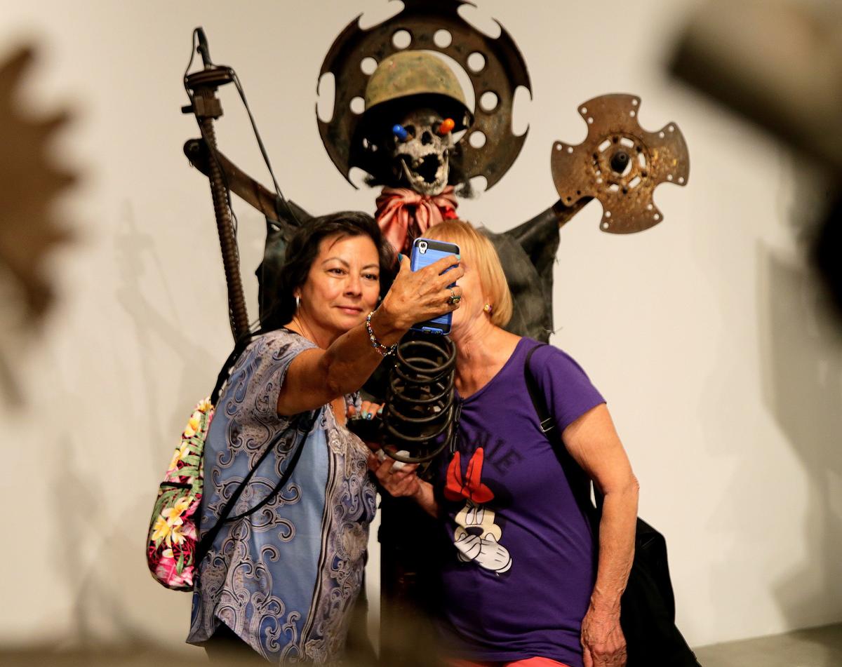Rosie Katz (left) and Patricia Bruschetta, take a selfie while standing next to Haitian artist Andre Eugene’s artwork at the Museum of Contemporary Art in North Miami. Eugene is among 20 Haiti-based artists exhibiting in the “PÒTOPRENS: The Urban Artists of Port-au-Prince.”