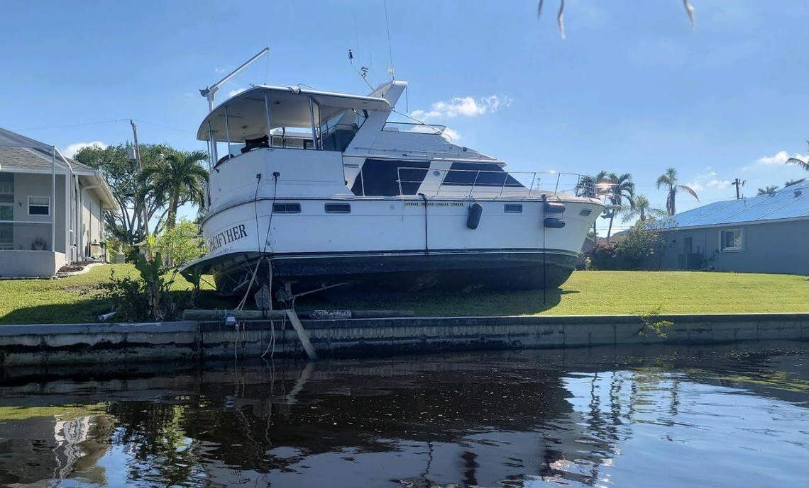 A large boat sits in the back yard of a home on Pine Island in Lee County Friday, Oct. 28, 2022. It’s one of thousands of displaced boats strewn across the area in the aftermath of Hurricane Ian.