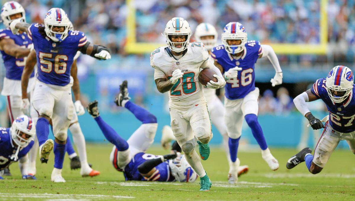 Miami Dolphins running back De'Von Achane (28) scores as he breaks tackles by Buffalo Bills defenders in the second half of an NFL football game at Hard Rock Stadium in Miami Gardens, Florida on Sunday, November 9, 2025.