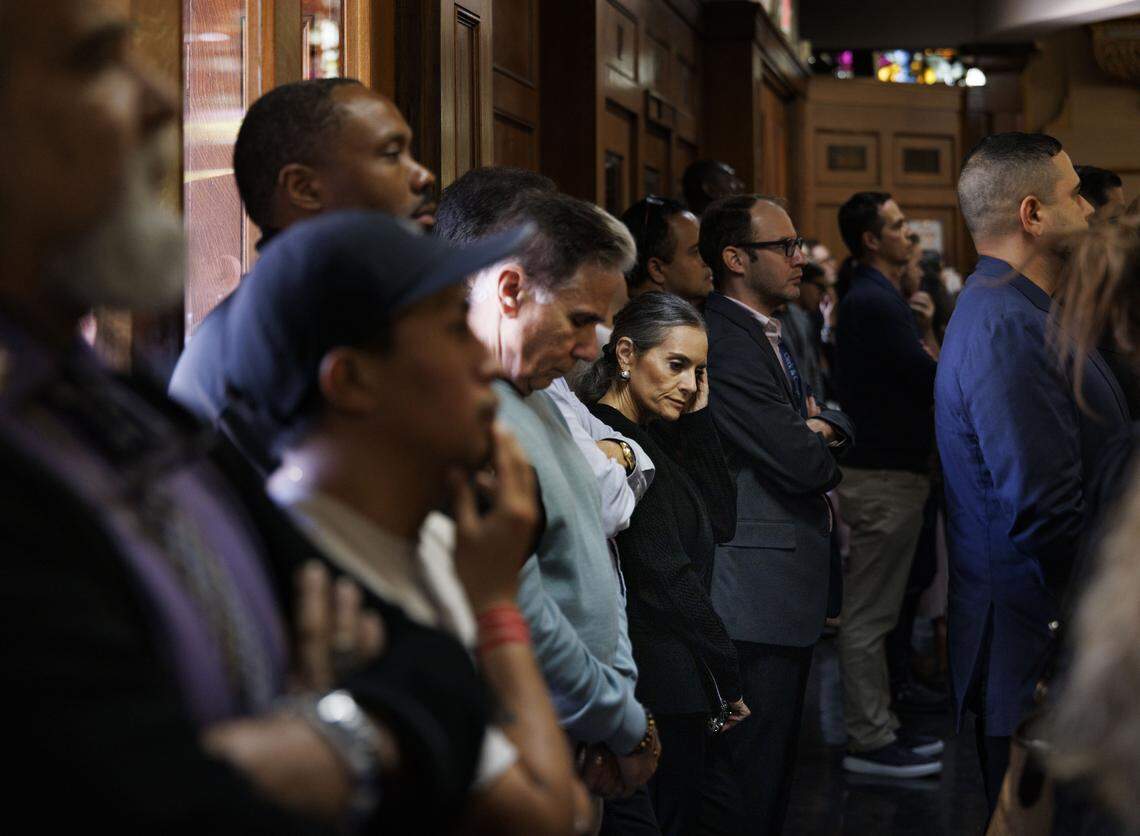 People stand in the back of the church due to it being full during Ash Wednesday mass on Wednesday, Feb. 18, 2026, at Gesu Catholic Church in downtown Miami. 