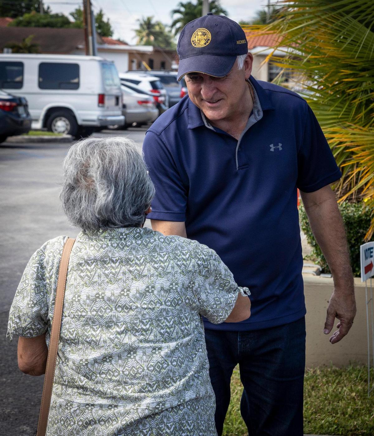 Esteban Bovo, candidato a la alcaldía de Hialeah, saluda a una electora en el estacionamiento de la biblioteca John F. Kennedy de Hialeah, el 27 de octubre de 2021,