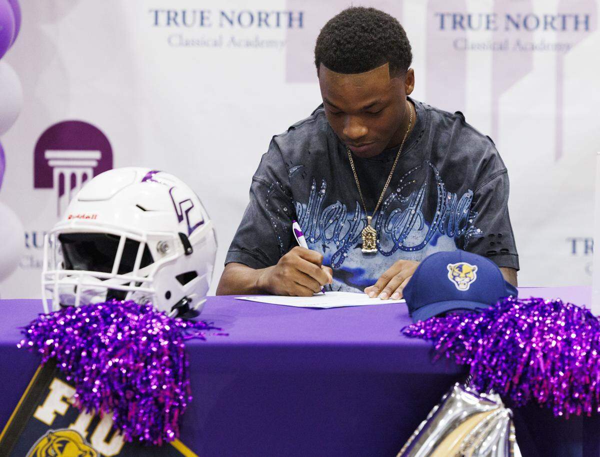 Malik Penson, Florida International University recruit, signs his letter of intent during Signing Day for True North football players on Wednesday, Dec. 3, 2025, at True North Classical Academy in Miami, Fla.