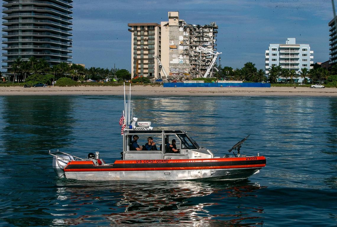 Coast Guard armed vessels are seen securing the area behind Champlain Towers South on July 1, 2021, one week after the building collapsed.