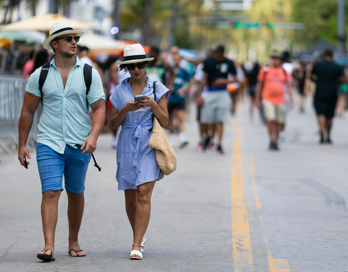Turistas pasean por Ocean Drive en Miami Beach el sábado, 14 de marzo. Para combatir la propagación del coronavirus, Miami Beach está cerrando una parte de la playa pública en South Beach por un tiempo indefinido.