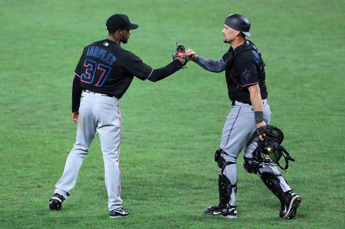 Miami Marlins relief pitcher Stephen Tarpley (37) and catcher Ryan Lavarnway react after defeating the Baltimore Orioles during the second game of a doubleheader, Wednesday, Aug. 5, 2020, in Baltimore. The Marlins won 2-1. (AP Photo/Julio Cortez)