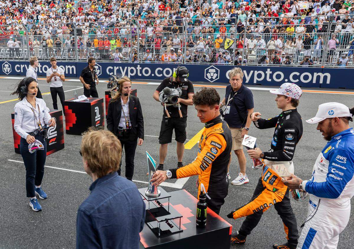 McLaren drivers Lando Norris of Britain, Oscar Piastri of Australia and Scuderia Ferrari driver Lewis Hamilton of Britain walk back to their garage after their Sprint race on the second day of the Formula One Miami Grand Prix at the Miami International Autodrome on Saturday, May 3, 2025, in Miami Gardens, Fla.