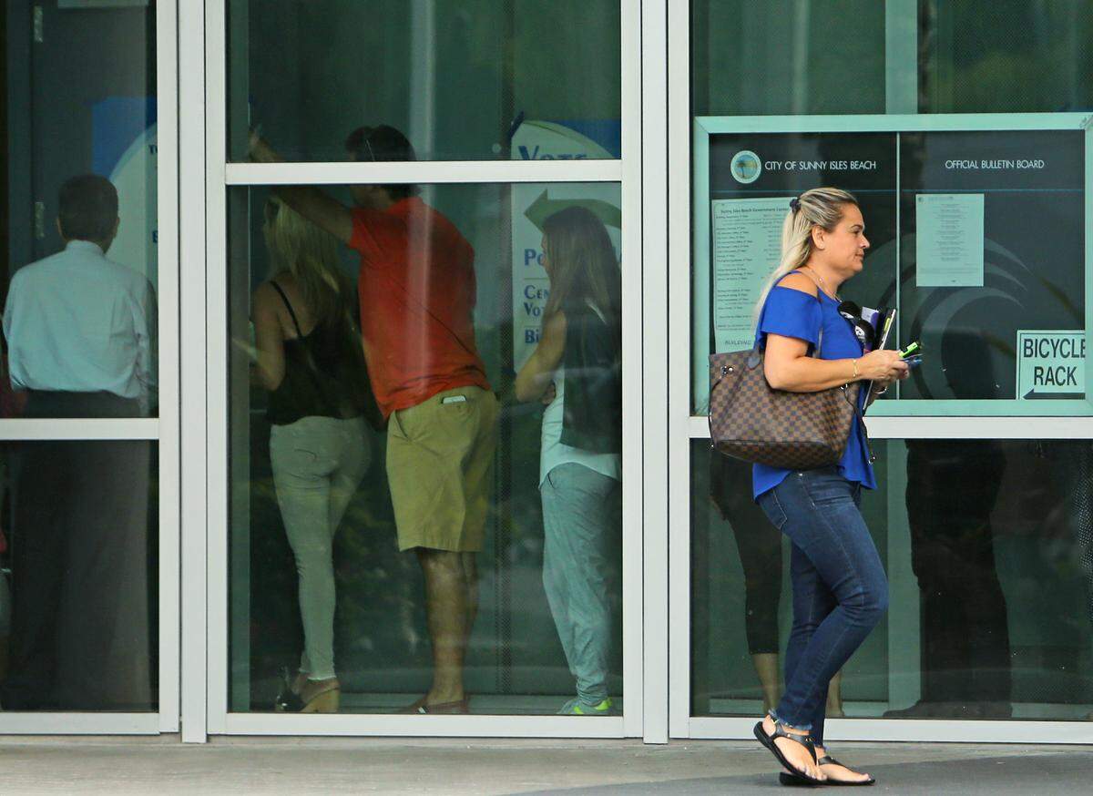 An unidentified woman arrive as voters line up at the Sunny Isles Beach City Hall during the midterm elections in Miami-Dade County on Tuesday, November 6, 2018.