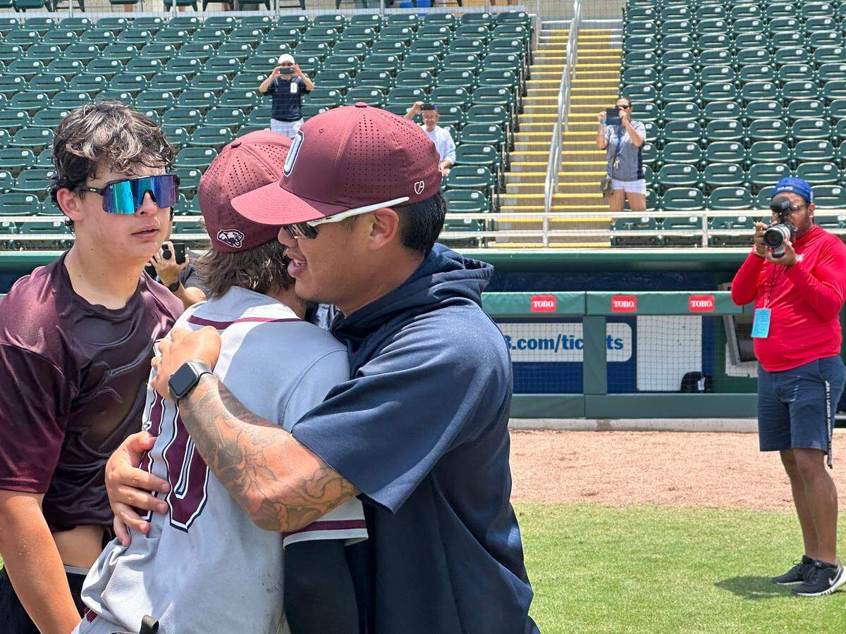 Former Miami Marlins pitcher Jordan Yamamoto, the baseball coach at Dwyer High in Palm Beach Gardens, hugs one of his players after winning the Class 6A state championship last week in Fort Myers, Fla.