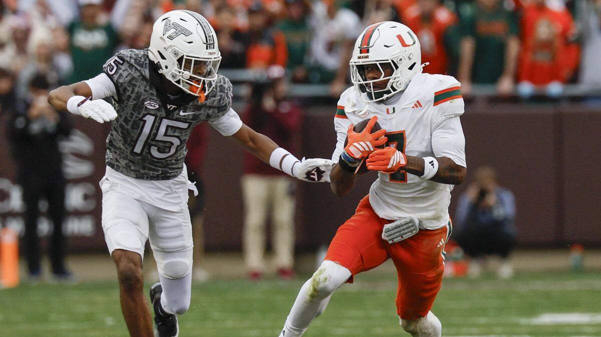 Miami Hurricanes safety Zechariah Poyser (7) recovers a fumble by Virginia Tech Hokies quarterback William Watson III (5) as Virginia Tech Hokies wide receiver Shamarius Peterkin (15) tries to make the stop in the second half at Lane Stadium in Blacksburg, Virginia, on Saturday, November 22, 2025.